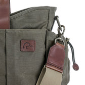Close-up of the Tom Beckbe DU Canvas Utility Bag in Wetlands Green with brown leather and duck logo patch.