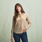 A woman wears the Tom Beckbe Womens Smyth Cotton Twill Shirt with blue jeans, standing against a light green background.