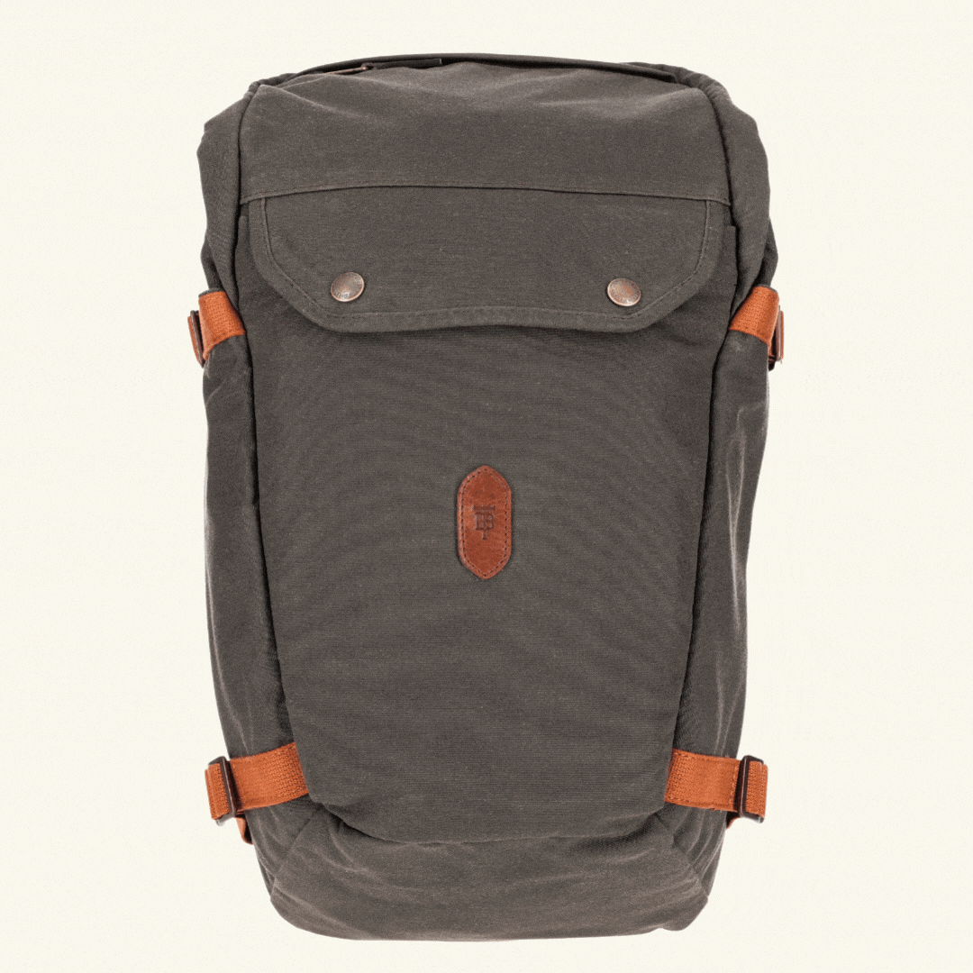 Dark gray backpack with a front pocket and brown straps on a light beige background.