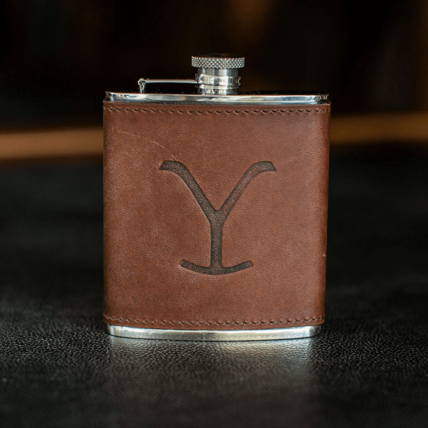 The Tom Beckbe Yellowstone Hip Flask (6oz) features a brown leather-wrapped metal design with an engraved Y.