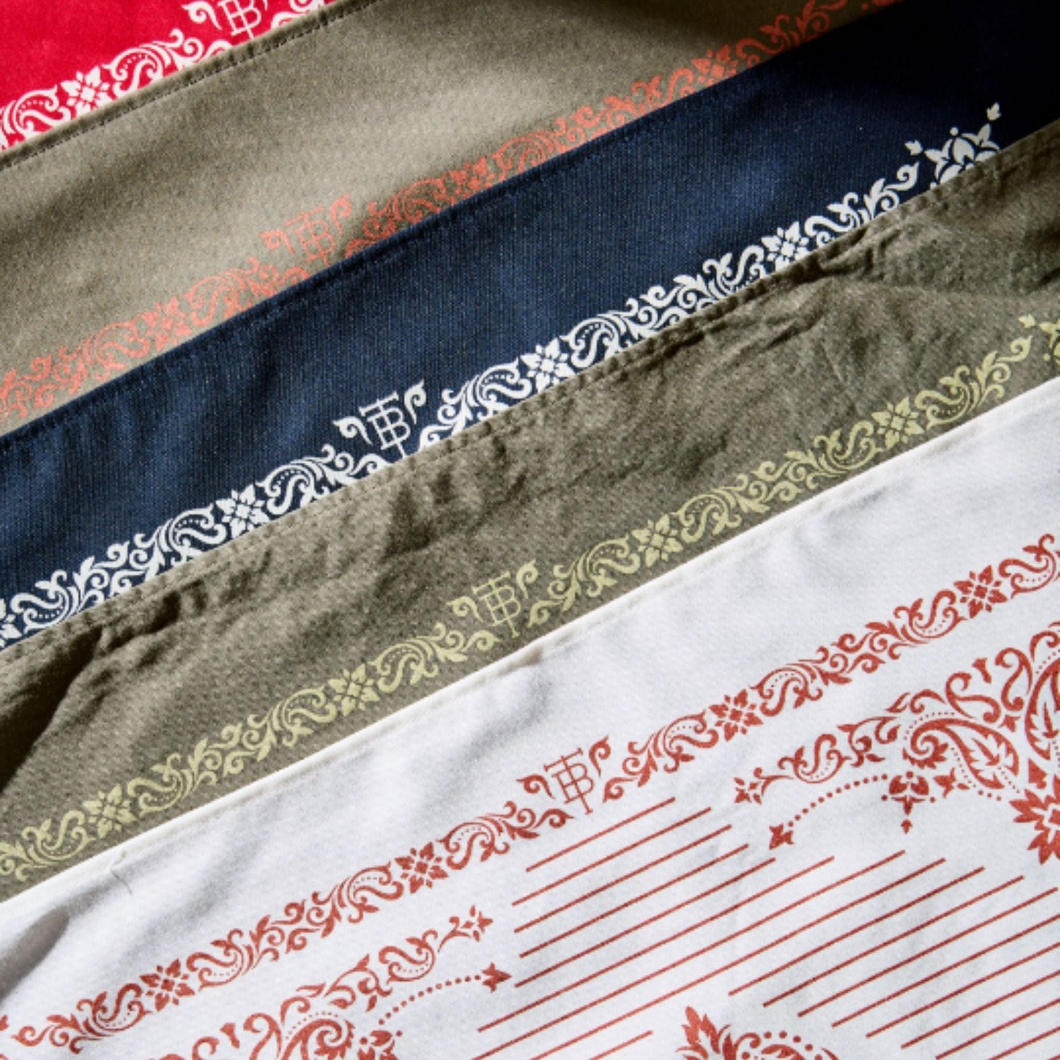 Variety of cotton bandanas featuring a western motif border with Tom Beckbe brand logo.